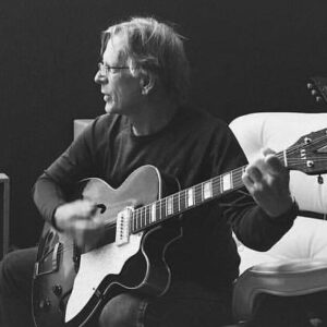 Dan Gore playing the guitar in a black and white photo